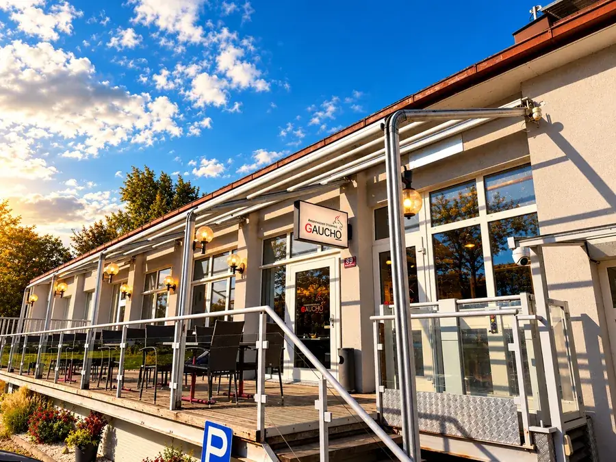 Das Restaurant Gaucho in Fußach: Eingang mit Schild und Terrasse im Abendlicht